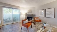 This 2-bedroom, 2-bathroom unit in West Valley City, Utah offers a well-organized single-floor layout designed for comfortable everyday living. The living room serves as the heart of the home, anchored by a classic brick fireplace and wood-style flooring that extends throughout the common areas. A sliding glass door fills the space with natural light and provides access to an outdoor area, creating an open, airy atmosphere.

The kitchen is thoughtfully appointed with crisp white shaker-style cabinetry, gray countertops, a stainless steel sink, and a full suite of appliances including a dishwasher, range, and refrigerator. A window above the counter brings in additional natural light, making the space bright and functional.

Both bathrooms feature gray countertops with white cabinetry consistent with the kitchen, wood-style flooring, and tub-shower combinations with curtained enclosures. The spacious primary bedroom is carpeted and includes a window with outdoor views, offering a quiet retreat. The second bedroom also features plush carpet flooring and ample space for a bed and a work desk. Textured ceilings are present throughout the unit, adding a classic residential character to every room.
