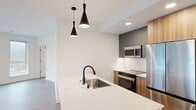 This contemporary apartment in Redmond, WA offers 1040 square feet of thoughtfully designed living space. The open-concept floor plan seamlessly integrates the kitchen and living areas, creating an inviting atmosphere for both relaxation and entertainment. The kitchen boasts modern stainless steel appliances, including a side-by-side refrigerator and built-in microwave, complemented by sleek cabinetry and a spacious island with a pristine quartz countertop.

The apartment features three bedrooms, with the primary bedroom measuring 120 square feet. Two well-appointed bathrooms showcase clean lines with white tile work and glass shower enclosures. Large windows throughout flood the space with natural light, while an in-unit laundry room adds convenience to daily living.

Attention to detail is evident in the consistent use of light wood-look flooring and neutral wall colors, creating a cohesive and contemporary aesthetic. The apartment also offers ample storage solutions, including spacious closets with built-in organizers. Climate control is ensured through a wall-mounted air conditioning unit, providing year-round comfort. This modern living space combines functionality and style, perfect for those seeking a turnkey home in the heart of Redmond.