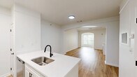Located at 7000 Johnson Farm Lane in Chadds Ford, PA, this thoughtfully designed one-bedroom, two-bathroom residence offers a clean, modern aesthetic throughout its well-utilized single-floor layout. The open-concept living area immediately impresses with vaulted ceilings and light hardwood flooring, creating an airy and welcoming atmosphere. A white-mantled fireplace serves as a focal point, complemented by pendant lighting and access to a windowed area that brings in natural light and greenery views.

The kitchen is a standout feature, outfitted with white shaker cabinetry, white quartz countertops, a peninsula with a stainless steel undermount sink, matte black fixtures, and stainless steel appliances including an electric range and refrigerator. The layout allows for seamless flow between the kitchen and living spaces.

The bedroom offers a comfortable footprint, fitted with plush carpeting, a large multi-pane window overlooking lush trees, and a six-panel closet door. Both bathrooms are finished with light hardwood-style flooring, white cabinetry, and clean, modern fixtures. One bathroom features a large vanity mirror, quartz countertop, and matte black hardware. A dedicated closet rounds out the functional layout of this well-appointed Chadds Ford residence.