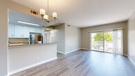 Located at 2075 Funny Cide St in Napa, CA, this single-floor, 3-bedroom, 3-bathroom home offers a well-designed layout with modern finishes throughout. The open-concept living and kitchen area serves as the heart of the home, featuring light gray luxury vinyl plank flooring, neutral-toned walls, and a stylish chandelier that adds a refined touch. Sliding glass doors lead to a private balcony, filling the space with natural light and offering pleasant outdoor views. The kitchen is appointed with crisp white cabinetry, granite countertops, stainless steel appliances — including a refrigerator, range, and microwave — and a breakfast bar peninsula ideal for casual dining. Three carpeted bedrooms provide comfortable retreats, each finished with soft neutral tones and ample wall space. The bathrooms are clean and functional; one features a sliding glass shower enclosure with a large mirror and bright window, while another includes a full shower-tub combo with white vanity cabinetry. Two closets and two hallways contribute to practical storage and circulation throughout the home. The overall ambiance is bright, clean, and move-in ready, making it a well-suited residence in the heart of Napa Valley.