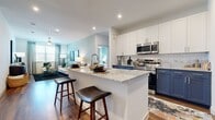 This thoughtfully designed 2-bedroom, 2-bathroom residence offers a seamless open-concept layout across a single floor. The kitchen is a standout centerpiece, featuring striking two-tone cabinetry with navy lower cabinets and crisp white uppers, granite countertops, subway tile backsplash, stainless steel appliances including a French door refrigerator, and a large island with bar seating — ideal for both cooking and casual dining. Rich hardwood-style flooring flows throughout the entire home, lending warmth and continuity to every space. The living room is bright and inviting, benefiting from large windows that bring in generous natural light, complemented by soft sage green accent walls and a ceiling fan. Each bedroom is well-sized and features large windows with outdoor views, hardwood-style flooring, and access to dedicated closets with built-in shelving and hanging rods. The bathrooms mirror the kitchen's design language, showcasing navy cabinetry, granite countertops, and clean white finishes. The primary bathroom features direct access to the walk-in closet, adding a practical and refined touch. Overall, the space maintains a cohesive modern aesthetic with a neutral and calming color palette throughout.