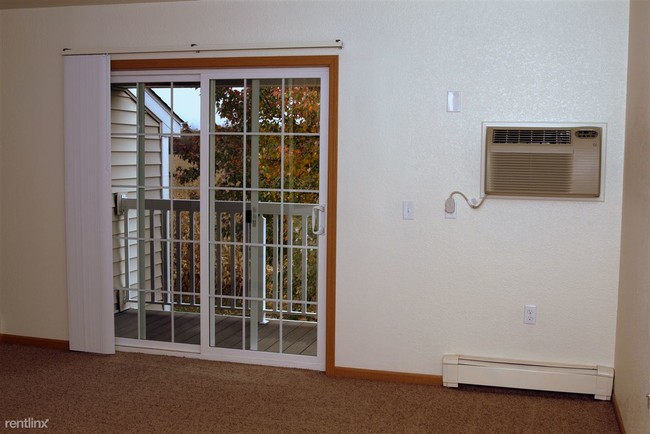 Patio off of dining/living area. Air conditioning in the wall. - Cherry Hill Manor Apartments