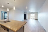 Located at 2065 South Cherokee Street in Denver's vibrant South Broadway corridor, this well-appointed 2-bedroom, 2-bathroom residence offers a thoughtfully designed single-level layout. The open-concept living, dining, and kitchen area forms the heart of the home, featuring light wood-look flooring that flows throughout. The contemporary kitchen is outfitted with two-tone shaker cabinetry — white uppers and gray lowers — paired with warm butcher block countertops, a white subway tile backsplash, and stainless steel appliances including a range and built-in microwave. Pendant lighting accents the kitchen peninsula, which opens seamlessly to the expansive living and dining area. Sliding glass doors lead to a private balcony, flooding the space with natural light and providing open outdoor views. Both bedrooms are finished with plush carpet and ceiling fans, with the primary bedroom offering generous proportions and access to its own closet. A dedicated pantry, in-unit laundry, and two full bathrooms with wood-look flooring round out the functional layout. Clean white walls, modern fixtures, and an airy, neutral palette give the entire residence a bright and contemporary ambiance.