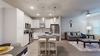Located in Saint Johns, FL, this thoughtfully designed one-bedroom, one-bathroom residence offers a efficient and functional single-floor layout. The open-concept living and kitchen area is anchored by light wood-look flooring that flows throughout the main living spaces, creating a bright and cohesive atmosphere. The kitchen is a standout feature, showcasing crisp white shaker cabinetry, granite countertops, a classic subway tile backsplash, and a full suite of stainless steel appliances including a range, microwave, dishwasher, and refrigerator. A center island with seating provides an ideal casual dining or entertaining space, illuminated by stylish pendant lighting overhead. The living room offers a relaxed, airy feel with neutral tones, a ceiling fan, and large windows that invite abundant natural light. The bedroom is carpeted for comfort, features a generous window, and is served by a dedicated closet. The bathroom includes a granite-topped vanity, wood-look tile flooring, and a tub-shower combo. Completing the unit, a dedicated laundry area houses a full-size washer and dryer, adding everyday convenience to this well-rounded residence.