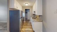 Located at 3641 Lancaster Ln N in Plymouth, Minnesota, this single-floor unit offers a thoughtfully updated interior with a clean, functional layout. The galley-style kitchen is a standout feature, showcasing white shaker cabinetry, granite countertops, a stainless steel refrigerator and range, and a undermount sink — all complemented by warm wood-look vinyl plank flooring that extends throughout the main living areas. A walk-in closet is conveniently accessible directly from the kitchen corridor, providing generous storage.

The living area is spacious and bright, featuring a bold accent wall in a deep teal hue, wood-look flooring, a baseboard heating unit, and a window that draws in natural light. The space opens toward the kitchen, creating a connected, easy-to-navigate flow. A separate area with its own access to a walk-in closet offers additional flexibility.

The bedroom is carpeted with neutral tones and features a wide window with vertical blinds, baseboard heating, and a textured ceiling, creating a quiet and comfortable retreat.

The bathroom is well-appointed with a granite-topped vanity, white cabinetry, tile flooring, and a full tub-shower combination with white tile surround and oil-rubbed bronze fixtures, adding a refined touch to the space.