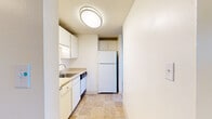 Located on Glenwood Drive in Boulder, Colorado, this single-floor, one-bedroom, one-bathroom residence offers a practical and comfortable layout. The main living area features neutral-toned carpeting and a textured ceiling, creating a clean and simple backdrop that is easy to personalize. The space flows into a compact, efficiently arranged kitchen equipped with white cabinetry, a stainless steel sink, a dishwasher, and a full-size refrigerator. Tile flooring in the kitchen adds a durable, easy-to-clean surface that complements the overall neutral palette. A carpeted hallway connects the living area to the bedroom and bathroom. The generously sized bedroom benefits from multiple windows that allow natural light to fill the room, along with a ceiling fan for added comfort. A wall-mounted air conditioning unit and baseboard heating provide year-round climate control. The bathroom features tile flooring, a vanity with a sink, a large mirror with Hollywood-style lighting, and a bathtub with decorative tiled surround accented by earthy, multicolored mosaic tile inlays. This straightforward and functional residence is well-suited for those seeking a comfortable home base in the heart of Boulder.