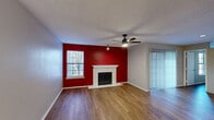 This 790 square foot single-story home in Dallas, TX offers a practical layout with 2 bedrooms and 1 bathroom. The living room serves as the focal point, featuring a striking red accent wall and a white fireplace, creating a warm and inviting atmosphere. Hardwood floors flow throughout the main living areas, while the bedrooms boast newer laminate flooring. The primary bedroom, measuring 150 square feet, includes a spacious closet with built-in shelving. The bathroom has been updated with modern fixtures, a glass shower door, and a wooden vanity. The kitchen, though not pictured, likely continues the home's contemporary feel. Ceiling fans in the living room and bedrooms provide air circulation, while large windows allow for ample natural light. The neutral color palette throughout most of the home offers a blank canvas for personalization. This compact yet efficiently designed space maximizes functionality in its 790 square feet, making it an ideal option for those seeking a low-maintenance home in the Dallas area.