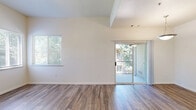 Located at 4262 W Figarden Dr in Fresno, CA, this one-bedroom, one-bathroom residence offers a well-organized single-floor layout designed for comfortable everyday living. The open-concept living and dining area is finished with wood-style laminate flooring and benefits from abundant natural light through multiple windows and a sliding glass door. The dining space features a stylish pendant light fixture and a ceiling fan, while the sliding door opens directly onto a private balcony with views of surrounding mature trees. The kitchen is thoughtfully designed with warm honey-toned wood cabinetry, tile countertops, a peninsula breakfast bar, and white appliances including a refrigerator, electric range, and built-in microwave. A separate interior door provides additional storage or utility access. The bedroom is a comfortable, well-proportioned retreat finished with plush carpeting, a ceiling fan with light kit, and a window that invites natural light and greenery views. The bathroom features wood-style flooring, a warm wood vanity with a white countertop, a glass-enclosed shower, and grab bar, offering both function and ease. Throughout the space, neutral tones and clean finishes create a bright, move-in-ready atmosphere.