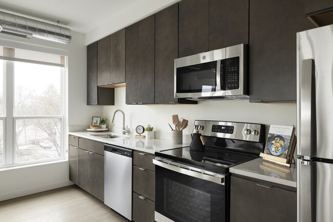 Rich cabinets, quartz counters, and modern fixtures complete this perfect and efficient kitchen setup - The Avandale