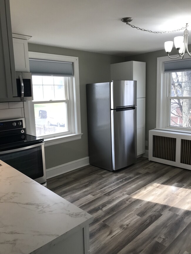 Newly renovated kitchen with white cabinets, subway tile backsplash, and stainless appliances - 430 Main St