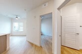 This well-designed 2-bedroom, 3-bathroom residence in Austin, TX offers a clean, modern aesthetic with light wood-style flooring and crisp white walls carried consistently throughout. The open-concept kitchen is a standout feature, showcasing a large quartz peninsula with an undermount sink, pendant lighting, white upper cabinetry, wood-toned lower cabinets, a subway tile backsplash, and a full suite of stainless steel appliances including a French door refrigerator, electric range, and microwave. The living area benefits from natural light through window blinds and is equipped with a ceiling fan for year-round comfort. Both bedrooms are bright and airy, each featuring light wood flooring, ceiling fans, and windows with blinds. The primary bedroom includes a walk-in closet with built-in shelving. The three bathrooms feature wood-toned cabinetry with white countertops and bold-framed mirrors, maintaining a cohesive modern style. One bathroom conveniently houses a stacked in-unit washer and dryer alongside a full tub-shower combination. Panel-style interior doors and recessed lighting add refined finishing touches throughout this thoughtfully designed Austin residence.