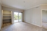 Located at 701 TC Jester Blvd in Houston, TX 77008, this one-bedroom, one-bathroom unit offers a well-organized, single-floor layout with a thoughtful mix of finishes and functional spaces. The entrance opens into a kitchen and dining area featuring wood-look hard surface flooring, white cabinetry, a gray tile backsplash, stainless steel appliances, and a granite-topped peninsula with pendant lighting and an integrated sink — ideal for both cooking and casual dining. A pantry provides additional storage nearby. The living room is carpeted and adorned with crown molding, and a sliding glass door leads to a private balcony with greenery views. A built-in nook with a granite desk surface and overhead shelving offers a dedicated workspace within the living area. The bedroom is carpeted with a ceiling fan, a natural light-filled window with wooded views, and direct access to both the bathroom and a closet. The bathroom is well-appointed with a granite vanity, white cabinetry, brushed nickel fixtures, and a tub-shower combination. The in-unit laundry room includes washer and dryer hookups with cabinetry for storage, completing this efficiently designed Houston residence.
