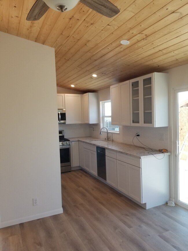 Kitchen with high wood ceiling, all new cabinets, stainless steel appliances and granite counters - 6832 Zelzah Ave