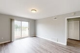 Located at 137 Princeton Ave in Claymont, Delaware, this well-appointed two-bedroom, two-bathroom home offers a thoughtfully designed single-floor layout. The interior is finished with light wood-style flooring throughout the main living areas and kitchen, complemented by soft gray walls and clean white trim that create a bright, neutral palette.

The living room is an inviting, open space bathed in natural light from a sliding glass door that leads directly to a private balcony with white railing, offering pleasant outdoor views. The kitchen is well-equipped with white shaker-style cabinetry, light countertops, and a full suite of stainless steel appliances including a refrigerator, range, microwave, and dishwasher, along with two windows that allow additional natural light.

Both bedrooms feature plush carpeting and soft gray walls. The primary bedroom is generously sized and connects to its own bathroom. The second bedroom includes a large window with outdoor views. Three closets throughout the home provide ample storage. The two bathrooms are clean and functional — one features a full tub/shower surround, while the other offers a pedestal sink and hardwood-style flooring. A utility room and hallway complete the efficient floor plan of this move-in-ready home.