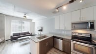 Located at 2030 Nueces St in Austin, TX, this modern 3-bedroom, 3-bathroom unit offers a well-designed single-floor layout with contemporary finishes throughout. The open-concept living and kitchen area serves as the heart of the home, featuring light wood-style flooring, exposed concrete architectural accents, and a ceiling fan that enhances the airy feel. Large windows allow natural light to fill the space and provide views of the surrounding cityscape.

The kitchen is outfitted with sleek white upper cabinetry, dark espresso lower cabinets, quartz countertops, stainless steel appliances including a refrigerator, microwave, and range, and a peninsula with bar seating — ideal for casual dining. The living area accommodates comfortable seating and a wall-mounted TV.

Each bedroom is compact yet functional, featuring wood-style flooring, large windows with horizontal blinds offering urban views, and individual closets with sliding doors. The bathrooms are finished with tile flooring, dark wood vanities, framed mirrors, and tub-shower combinations. An in-unit laundry area houses a full-size washer and dryer. A connecting hallway ties all rooms together efficiently, making this unit a practical and stylish option in the heart of Austin.