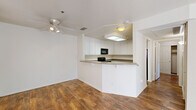 Located at 1175 Lake Blvd in Davis, CA, this single-floor, 2-bedroom, 2-bathroom residence offers a well-organized layout designed for comfortable everyday living. The living room is bright and open, featuring warm hardwood-style flooring, a ceiling fan with light fixture, and two sets of sliding glass doors dressed with vertical blinds that invite abundant natural light and provide direct access to an outdoor patio area.

The kitchen is positioned adjacent to the living area in a peninsula layout, offering generous white cabinetry, stone-toned countertops, and black appliances including an electric range and over-the-range microwave. A built-in breakfast bar adds functional convenience to the space.

Both bedrooms are carpeted and feature windows with outdoor views, providing a quiet, comfortable retreat. The primary bedroom is a well-proportioned space with views of the surrounding greenery. The two bathrooms continue the hardwood-style flooring found throughout the main living areas. One bathroom features a wide vanity with white cabinetry and a large mirror, while the second is a more compact water closet-style layout. Two hallways connect the rooms efficiently, and a dedicated closet provides additional storage within the unit.