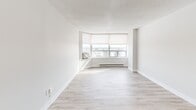 Located at 200 Denistoun St in Welland, Ontario, this 2-bedroom, 1-bathroom unit offers a clean, modern aesthetic throughout. Light wood laminate flooring flows seamlessly across the living areas, complemented by crisp white walls and textured ceilings that add depth to each room. The combined kitchen and living area forms the heart of the unit, featuring a well-appointed kitchen with white cabinetry, stone-look countertops, a subway tile backsplash, and a full suite of stainless steel appliances including a refrigerator, electric range, dishwasher, and over-the-range microwave. A peninsula counter connects the kitchen to the open living space, maximizing functionality. The bright living room is anchored by a striking corner window arrangement fitted with roller blinds, offering broad panoramic views of the Welland cityscape and filling the space with abundant natural light. Both bedrooms are comfortably sized, each featuring double-door closets, large windows with outdoor views, and baseboard heating. The primary bedroom provides a generous layout with ample storage. The bathroom is finished with large-format floor tiles, a full tub-shower combo with white tile surround, a vanity with granite-style countertops, and white cabinetry. A dedicated entrance and hallway complete the well-organized layout.