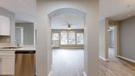 This contemporary single-story residence in Orlando offers 1,120 square feet of thoughtfully designed living space. The home boasts four bedrooms, including a spacious 210 sq ft primary suite, and two full bathrooms. The open floor plan creates a seamless flow between the kitchen, living, and dining areas, ideal for both everyday living and entertaining.

Throughout the home, modern finishes elevate the aesthetic. Light grey walls complement the striking wood-look flooring, creating a bright and airy atmosphere. Ceiling fans in multiple rooms provide comfort and air circulation. The kitchen features sleek white cabinetry, stainless steel appliances, and a convenient layout.

The bathrooms showcase clean lines with white vanities, large mirrors, and updated fixtures. Built-in shelving and closet spaces offer practical storage solutions. Large windows, including arched designs in the living area, flood the rooms with natural light and provide views of the surrounding greenery.

The property's thoughtful design extends to the laundry room, equipped with full-sized appliances. With its blend of style and functionality, this home presents an attractive option for those seeking a contemporary living space in Orlando's Villa Point neighborhood.