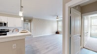 This well-appointed single-story, 3-bedroom, 2-bathroom home on Welaunee Boulevard in Tallahassee, FL offers a thoughtfully designed layout with a warm, neutral palette throughout. Light-toned luxury vinyl plank flooring flows through the open-concept living and kitchen areas, complemented by crown molding and ceiling fans for a polished finish. The living room is a standout, featuring a corner electric fireplace with a crisp white surround and direct access to a private balcony overlooking lush greenery. The kitchen impresses with white shaker cabinetry, quartz-style countertops, a classic tile backsplash, stainless steel appliances, and a peninsula that enhances both prep space and casual dining. The generously sized primary bedroom offers ample room to furnish comfortably, while all three bedrooms feature plush carpeting, ceiling fans, and natural light from large windows with blinds. Each bedroom benefits from dedicated closet space, including walk-in closets with wire shelving systems. The bathrooms are clean and contemporary, with the full bath showcasing an extended vanity with white cabinetry, a large mirror, and a tub-shower combination. A utility room and multiple hallways add practical storage and circulation throughout this comfortable Tallahassee home.