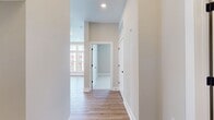 This 650 square foot apartment efficiently utilizes its single-floor layout to offer a comfortable living space. The property features one bedroom, measuring 160 square feet, and one bathroom. The open-concept design integrates the kitchen and living room, maximizing the available space and creating a sense of openness.

A standout feature of this apartment is its impressive window arrangement. Large, multi-paned windows stretch from floor to ceiling, allowing ample natural light to flood the interior. These windows not only brighten the space but also offer expansive views of the surrounding area, enhancing the perception of space within the apartment.

The flooring throughout is a warm, wood-look material, likely luxury vinyl plank, which adds a touch of elegance and warmth to the space. The walls are painted in a neutral, light color, further contributing to the bright and airy atmosphere.

Despite its compact size, the apartment includes a closet for storage. The kitchen and living areas, while not visible in the image, are designed to maximize functionality in the limited square footage. This property is ideal for those seeking a modern, low-maintenance living space with an emphasis on natural light and efficient design.
