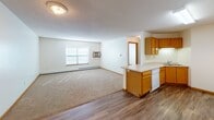 Located at 680 12th St SW in Forest Lake, Minnesota, this single-floor unit offers a practical and comfortable layout designed for everyday living. The open-concept main area seamlessly connects the kitchen and living room, creating a versatile and functional space. The kitchen features warm honey-toned oak cabinetry, a peninsula with counter seating, white appliances including an electric range and dishwasher, and durable wood-look vinyl flooring. A built-in range hood and ample upper and lower cabinet storage add to the kitchen's practicality. The living area transitions to plush carpeting, providing a comfortable setting accented by a window that allows natural light to fill the room. A wall-mounted air conditioning unit and baseboard heating ensure year-round comfort. The bedroom is generously sized with soft carpeting, a bright window, and baseboard heating. The bathroom is finished with oak cabinetry, a tall linen-style storage cabinet, a single vanity with a large mirror, and wood-look vinyl flooring. Textured ceilings and warm wood trim are consistent throughout, giving the space a cohesive and inviting character.