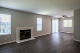 Located at 3907 Pierce St in Riverside, California, this single-story home presents a clean, modern aesthetic carried consistently throughout its interior. Wood-look plank flooring runs through the living areas and bedrooms, providing a cohesive and low-maintenance foundation underfoot. Neutral gray-toned walls complement the light-filled rooms, which are fitted with white horizontal blinds across multiple windows.

The spacious living area serves as the heart of the home, featuring a white-surround fireplace with brass-framed glass doors as a central focal point, flanked by windows that invite natural light. A ceiling fan and sliding glass door add comfort and outdoor access. A second living or dining area connects seamlessly, enhancing the open flow of the floor plan.

The kitchen is outfitted with light wood cabinetry, white quartz countertops, and a full suite of stainless steel appliances, including a range, over-the-range microwave, and refrigerator. The bedrooms are well-proportioned, each featuring ceiling fans and windows with outdoor views. Two full bathrooms serve the home — one with a tub/shower combination and dark hardware accents, and another with a sliding glass-door walk-in shower and matching fixtures.