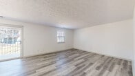 Located at 13500 Chenal Pkwy in Little Rock, Arkansas, this single-floor unit offers a well-organized layout with a clean, neutral aesthetic throughout. The updated kitchen is a standout feature, equipped with stainless steel appliances including a range, microwave, and dishwasher, complemented by white cabinetry, granite-style countertops, and a gray subway tile backsplash. A window above the sink provides natural light, while wood-look luxury vinyl flooring ties the space together. The living and dining areas continue the wood-look flooring and feature textured ceilings and crisp white walls, creating a bright and open atmosphere. The bedrooms are carpeted for comfort, each outfitted with ceiling fans and closets with sliding doors. The primary bedroom includes an en-suite bathroom and direct access to an additional room, offering added functionality. Bathrooms are finished with wood-look flooring; one features a tub-shower combo with tile surround and granite-topped vanity, while another includes a walk-in glass-door shower with brushed nickel fixtures. Throughout the unit, blinds on the windows offer privacy and light control, contributing to the space's clean and move-in ready presentation.