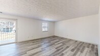 Located at 13500 Chenal Pkwy in Little Rock, Arkansas, this single-floor unit offers a well-organized layout with a clean, neutral aesthetic throughout. The updated kitchen is a standout feature, equipped with stainless steel appliances including a range, microwave, and dishwasher, complemented by white cabinetry, granite-style countertops, and a gray subway tile backsplash. A window above the sink provides natural light, while wood-look luxury vinyl flooring ties the space together. The living and dining areas continue the wood-look flooring and feature textured ceilings and crisp white walls, creating a bright and open atmosphere. The bedrooms are carpeted for comfort, each outfitted with ceiling fans and closets with sliding doors. The primary bedroom includes an en-suite bathroom and direct access to an additional room, offering added functionality. Bathrooms are finished with wood-look flooring; one features a tub-shower combo with tile surround and granite-topped vanity, while another includes a walk-in glass-door shower with brushed nickel fixtures. Throughout the unit, blinds on the windows offer privacy and light control, contributing to the space's clean and move-in ready presentation.