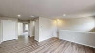 Located at 80 River Chase Dr in Dover, Delaware, this one-bedroom, one-bathroom residence offers a well-designed single-floor layout with a practical and cohesive interior. The combined kitchen and living area forms the heart of the home, featuring wood-look luxury vinyl plank flooring, neutral-toned walls, and recessed lighting. The kitchen is outfitted with crisp white cabinetry, a suite of black appliances including a refrigerator, dishwasher, and range, along with a single-basin sink and a louvered-door closet for additional storage. The open living area benefits from large windows dressed with horizontal blinds, allowing natural light to fill the space, and includes a half-wall partition that adds architectural definition. The bedroom is a comfortable, well-proportioned retreat featuring plush wall-to-wall carpeting, vaulted ceilings that lend a sense of openness, and a large window providing natural light. A dedicated closet adds convenient storage directly off the bedroom. The bathroom is cleanly finished with a white vanity, a mirrored medicine cabinet with overhead lighting, a toilet, and a full bathtub with shower, all set on wood-look flooring that ties in with the rest of the home. The overall aesthetic is clean, modern, and move-in ready.