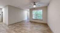Located at 7121 Finn Hall Ave in Charlotte, NC, this two-story home offers 2 bedrooms and 2 bathrooms across a well-designed layout. The main level features an open-concept kitchen and living area with light wood-look flooring. The kitchen is equipped with stainless steel appliances—including a refrigerator, range, microwave, and dishwasher—complemented by gray shaker-style cabinetry, granite countertops, and a classic white subway tile backsplash. The adjacent living area is bright and airy, with a ceiling fan and a large window framing lush greenery views outside. Upstairs, the two bedrooms each feature ceiling fans, wood-look flooring, and windows with natural light and outdoor views. The primary bedroom is generously sized and includes access to a dedicated closet with wire shelving for ample storage. Both bathrooms are finished with granite-topped white vanities, wood-look tile flooring, and tub/shower combinations with tile surrounds and curved curtain rods. Additional walk-in closet space and two staircases complete the functional layout of this well-appointed Charlotte home.