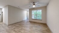 Located at 7121 Finn Hall Ave in Charlotte, NC, this two-story home offers 2 bedrooms and 2 bathrooms across a well-designed layout. The main level features an open-concept kitchen and living area with light wood-look flooring. The kitchen is equipped with stainless steel appliances—including a refrigerator, range, microwave, and dishwasher—complemented by gray shaker-style cabinetry, granite countertops, and a classic white subway tile backsplash. The adjacent living area is bright and airy, with a ceiling fan and a large window framing lush greenery views outside. Upstairs, the two bedrooms each feature ceiling fans, wood-look flooring, and windows with natural light and outdoor views. The primary bedroom is generously sized and includes access to a dedicated closet with wire shelving for ample storage. Both bathrooms are finished with granite-topped white vanities, wood-look tile flooring, and tub/shower combinations with tile surrounds and curved curtain rods. Additional walk-in closet space and two staircases complete the functional layout of this well-appointed Charlotte home.