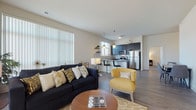 Located at 5300 S 76th St in Greendale, Wisconsin, this single-floor residence offers a well-designed open-concept layout that seamlessly connects the living, dining, and kitchen areas. The living room is bright and welcoming, featuring large windows with vertical blinds that allow generous natural light, wood-style flooring, and a comfortable, modern aesthetic.

The kitchen is a standout feature, equipped with dark cabinetry extending to the ceiling, granite countertops, a subway tile backsplash, and a full suite of stainless steel appliances including a refrigerator, range, and built-in microwave. A breakfast bar with bar seating provides a casual dining option and further integrates the kitchen with the living space.

The bedroom is a calm retreat, carpeted for comfort, with a window that frames outdoor views and easy access to an adjoining bathroom. Two bathrooms serve the residence — one featuring a granite-topped dark vanity with a tub/shower combo, and the other offering a spacious layout with a granite vanity and wood-look tile flooring. Both bathrooms maintain a consistent, modern design language with dark cabinetry and brushed nickel hardware. Overall, the space presents a clean, contemporary feel with cohesive finishes throughout.