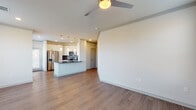 This well-appointed single-floor residence offers a thoughtfully designed open-concept layout that seamlessly connects the living and kitchen areas. The living space features warm wood-look flooring, crown molding, and a ceiling fan, creating a comfortable and cohesive atmosphere. Natural light flows in through multiple windows, enhancing the bright, airy feel of the space.

The kitchen is a standout feature, boasting crisp white cabinetry that extends to the ceiling for ample storage, dark granite-style countertops, and a striking hexagonal tile backsplash. A peninsula with pendant lighting provides additional counter space and a casual dining option. Stainless steel appliances — including a French door refrigerator with ice and water dispenser, electric range, microwave, and dishwasher — complete the modern kitchen.

The bedrooms are carpeted for comfort, with ceiling fans and windows that bring in natural light. One bedroom features a distinctive bay window arrangement, adding architectural charm. The bathroom is elegantly finished with white cabinetry, dark countertops, a glass-enclosed tiled shower, and wood-look flooring, lending a clean and contemporary aesthetic throughout. This residence offers a balanced combination of functional design and modern finishes.