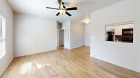 Located in Lumberton, Texas, this single-story, 2-bedroom, 1-bathroom home offers a practical and well-organized layout. The living room serves as the heart of the home, featuring warm wood-look flooring, a ceiling fan with light fixture, and a window that allows natural light to brighten the space. The room flows seamlessly toward the front entry door, creating an open and welcoming atmosphere.

The kitchen is efficiently designed in a galley-style configuration, outfitted with white cabinetry, open shelving for additional storage, a stainless-style refrigerator, a range, and a sink with countertop workspace. Wood-look flooring continues throughout, maintaining a cohesive aesthetic.

Both bedrooms are carpeted and finished with neutral tones, providing a clean and comfortable retreat. The primary bedroom is generously proportioned and includes a closet. The secondary bedroom also features a window with outdoor views of the surrounding greenery. Each room benefits from natural light through slatted blinds.

The bathroom is complete with a shower-tub combination, toilet, sink, and overhead cabinetry for storage, all set on wood-look flooring. Two closets throughout the home offer practical storage solutions. The overall design is clean, neutral, and move-in ready.