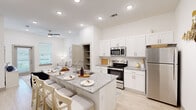 This thoughtfully designed one-bedroom, one-bathroom unit in Gonzales, Louisiana presents a clean, contemporary aesthetic throughout its single-floor layout. The open-concept living and kitchen area is anchored by light wood-look flooring, crisp white walls, and recessed lighting complemented by ceiling fans, creating a bright and airy atmosphere.

The kitchen is a functional centerpiece, featuring white shaker-style cabinetry, granite countertops, stainless steel appliances including a refrigerator, range, and microwave, and a peninsula with bar seating — ideal for casual dining or entertaining. A built-in open shelving unit provides additional storage adjacent to the living area.

The living room offers comfortable proportions, natural light from a sliding door with outdoor access, and a ceiling fan overhead. The serene bedroom features a ceiling fan, a large window with natural light, and easy access to the full bathroom.

The bathroom is finished with granite countertops, white cabinetry with modern hardware, and light wood-look flooring. A generously sized walk-in closet with wrap-around shelving and hanging rods provides excellent storage capacity. The unit also includes an in-unit laundry area, completing a well-rounded and highly functional living space.