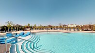 Located at 7027 Park Mill Dr in Plain City, Ohio, this single-level community amenity space centers around a beautifully designed resort-style outdoor swimming pool. The pool itself features a gradual entry with elegant curved steps, making it accessible and inviting for all ages. Crystal-clear blue water fills the generously sized pool, which is framed by a spacious surrounding deck finished in light-toned pavement. The deck is well-appointed with a row of classic lounge chairs arranged along the pool's edge, ideal for sunbathing and relaxation. Striped canopy umbrellas provide shaded retreats throughout the space, while a cozy hanging lounge pod offers a charming spot to unwind. A decorative lamp post adds a touch of classic style to the area. The facility is enclosed by a clean black iron fence, ensuring safety while maintaining open sightlines to the lush surroundings and the residential neighborhood beyond. Mature trees and open skies contribute to a bright, airy atmosphere. The overall design of the space reflects a well-maintained, community-focused amenity that prioritizes both functionality and aesthetic appeal, making it a standout gathering place for residents.