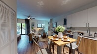 Located at 18325 S Dixie Hwy in Palmetto Bay, Florida, this single-floor residence offers a thoughtfully designed open-concept layout that seamlessly integrates the kitchen, dining, and living areas into one cohesive space. Rich wood-look flooring flows throughout, lending warmth and continuity to every room.

The kitchen is a standout feature, equipped with stainless steel appliances including a refrigerator, electric range, built-in microwave, and dishwasher. Crisp white upper cabinetry is paired with wood-toned lower cabinets, complemented by a clean countertop and a functional single-basin sink. Adjacent to the kitchen, a bistro-style dining area provides an inviting space for casual meals.

The open living and sleeping area is bright and airy, benefiting from multiple windows and sliding glass doors that invite natural light and offer views of tropical greenery. A ceiling fan enhances comfort, while the versatile layout accommodates both a lounge seating arrangement and a bedroom setup with ample closet storage nearby.

The bathroom is well-appointed with a wood-grain vanity, white countertop, and a tiled tub-shower combination, reflecting the same modern aesthetic found throughout the residence. The overall ambiance is warm, contemporary, and move-in ready.