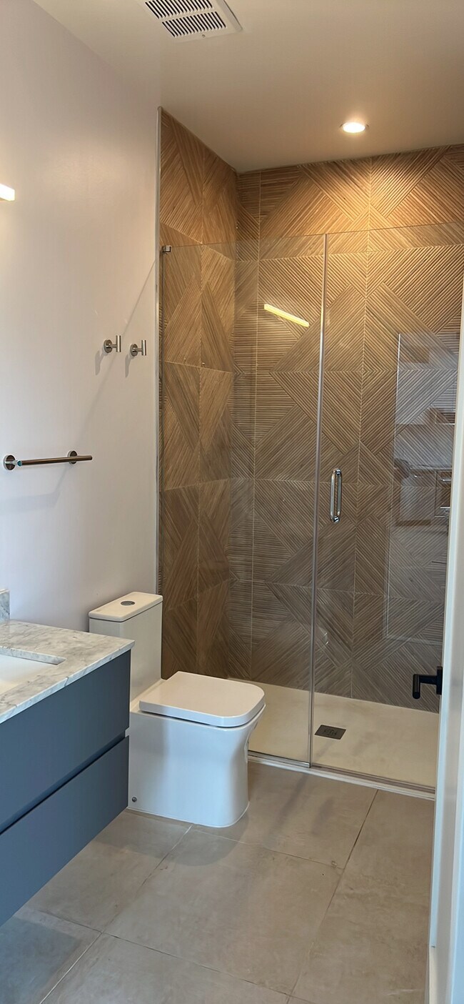 Spacious bathroom with spot lit glass shower. Walk in closet in bathroom. Built in drawers in vanity - 7700 Georgia Ave NW
