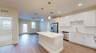 Located at 1023 Gull Ln in Melbourne, FL, this well-appointed 2-bedroom, 2-bathroom residence offers a thoughtfully designed single-floor layout with clean, contemporary finishes throughout. The open-concept kitchen flows seamlessly into the dining and living areas, creating a bright and functional central hub. The kitchen is outfitted with crisp white shaker cabinetry, stainless steel appliances including a French door refrigerator, microwave, range, and dishwasher, and a large center island with pendant lighting — ideal for both meal preparation and casual dining. Light wood-tone flooring extends throughout the main living areas, complementing the neutral color palette.

The primary bedroom is generously sized and features hardwood-style flooring, a ceiling fan, and access to a well-appointed en suite bathroom. The primary bath boasts a long double-sink vanity with illuminated mirrors and a glass-enclosed walk-in tile shower. The second bedroom is carpeted and filled with natural light from multiple windows. Four closets provide ample storage throughout the unit, including walk-in options with wire shelving systems. A dedicated laundry area adds everyday convenience. The private balcony offers open views of the surrounding Melbourne landscape, completing this modern and comfortable residence.