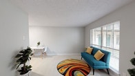 This single-floor unit offers a thoughtfully arranged layout that maximizes its comfortable footprint. The open living area is finished with light-toned flooring, neutral gray walls, and a textured ceiling, creating a bright and airy atmosphere. A window fitted with horizontal blinds allows natural light to fill the space while providing privacy. The living area flows naturally into a compact dining nook, making the layout practical and easy to navigate.

The kitchen is well-equipped, featuring white raised-panel cabinetry, granite countertops with speckled detailing, a stainless steel sink, a gas range with overhead ventilation, and white subway tile backsplash. The clean, cohesive design gives the kitchen a polished, functional feel.

The bedroom is a calm retreat with neutral gray walls, light carpet underfoot, and a window overlooking greenery, bringing in soft natural light and a connection to the outdoors. The textured ceiling carries throughout the unit, maintaining visual consistency.

The bathroom features a full tub-shower combination with white tile surround, a single-sink vanity, and a bold deep green accent wall that adds a distinct, memorable character to the space.