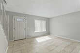Located in Moreno Valley, California, this two-story, two-bedroom, two-bathroom home offers a functional and well-organized layout spread across two floors. The main level provides the primary living spaces, including a bright living room with light tile flooring and vertical blinds that allow natural light to filter in. The combined dining room and kitchen area is efficiently designed, featuring white cabinetry, granite-style countertops, a gas range, and a sliding door that opens directly to a private patio. A full bathroom on the upper level includes a tiled tub-and-shower combination with a decorative mosaic border accent, complemented by a clean white vanity. A second bathroom features a streamlined white vanity with overhead lighting and mirrored storage. Both bedrooms are found on the upper floor, including a generously sized primary bedroom with wood-style flooring, a walk-in closet, and a mirrored sliding-door closet. The second bedroom offers tile flooring and a large window with outdoor views. Throughout the home, textured ceilings, neutral wall tones, and light flooring create a cohesive, airy aesthetic. Additional highlights include a dedicated laundry area, multiple utility spaces, and ample closet storage across both levels.