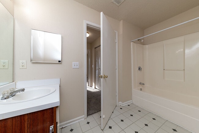 Bright bathroom with tile flooring & bathtub - Creekside