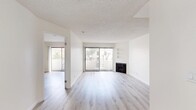 Located in the heart of Los Angeles' Koreatown neighborhood, this two-bedroom, one-bathroom residence offers a well-designed single-floor layout with clean, modern finishes throughout. Light wood-style flooring runs continuously through the unit, creating a cohesive and airy feel from room to room.

The open living area is a standout feature, anchored by a classic fireplace and built-in wall shelving. Large sliding glass doors flood the space with natural light and provide direct access to an outdoor balcony, offering views of the surrounding palm tree-lined streetscape. Vertical blinds provide adjustable light control. A ceiling fan is present near the entry, enhancing comfort and circulation.

The kitchen is efficiently designed with crisp white cabinetry, granite-style countertops, stainless steel appliances including a gas range and built-in microwave, and durable wood-look flooring — a practical and stylish space for everyday cooking.

Both bedrooms are bright and well-proportioned, with the second bedroom also featuring a sliding glass door that opens to an outdoor area with greenery views. The primary bedroom connects conveniently to the full bathroom, which is outfitted with white cabinetry, granite countertops, and a tub-shower combination with a sliding glass enclosure. Textured ceilings are present throughout, adding a traditional touch to the otherwise clean, updated interior.