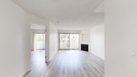 Located in the heart of Los Angeles' Koreatown neighborhood, this two-bedroom, one-bathroom residence offers a well-designed single-floor layout with clean, modern finishes throughout. Light wood-style flooring runs continuously through the unit, creating a cohesive and airy feel from room to room.

The open living area is a standout feature, anchored by a classic fireplace and built-in wall shelving. Large sliding glass doors flood the space with natural light and provide direct access to an outdoor balcony, offering views of the surrounding palm tree-lined streetscape. Vertical blinds provide adjustable light control. A ceiling fan is present near the entry, enhancing comfort and circulation.

The kitchen is efficiently designed with crisp white cabinetry, granite-style countertops, stainless steel appliances including a gas range and built-in microwave, and durable wood-look flooring — a practical and stylish space for everyday cooking.

Both bedrooms are bright and well-proportioned, with the second bedroom also featuring a sliding glass door that opens to an outdoor area with greenery views. The primary bedroom connects conveniently to the full bathroom, which is outfitted with white cabinetry, granite countertops, and a tub-shower combination with a sliding glass enclosure. Textured ceilings are present throughout, adding a traditional touch to the otherwise clean, updated interior.