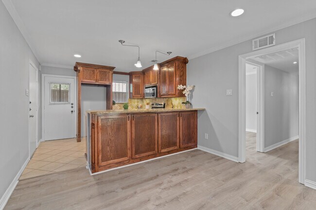 Breakfast Bar & Kitchen view of Patio Door and Hallway to Bedrooms - 5084 Matilda St