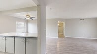 Located at 5205 Fairbanks Dr in El Paso, Texas, this 2-bedroom, 2-bathroom single-story home offers a practical and well-appointed layout throughout. Light wood-style flooring flows consistently across the living areas, bedrooms, and hallway, creating a cohesive and clean aesthetic. Neutral gray wall tones and white trim complement the bright, airy feel of each room.

The combined kitchen and living area serves as the heart of the home. The kitchen features gray cabinetry, white countertops, a classic white subway tile backsplash, and black appliances including a refrigerator, gas range, and dishwasher. A peninsula provides additional counter space and separates the kitchen from the living area. The living room is generously sized, illuminated by natural light from a large sliding glass door that opens to an outdoor patio. A ceiling fan adds comfort to the adjacent dining area.

The spacious primary bedroom offers dual closets with hanging rods, providing ample storage. The second bedroom is well-sized with a window for natural light. Both bathrooms are finished with gray vanity cabinetry, white countertops, and light wood-style flooring. A hallway connects the bedrooms and bathrooms, completing the efficient single-floor layout. Textured ceilings are present throughout the home.