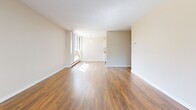 Located at 1552 Esquimalt Avenue in West Vancouver, BC, this well-appointed one-bedroom, one-bathroom unit offers a thoughtfully laid-out single-floor plan with a comfortable sense of space throughout.

The living room is the standout feature of the unit, highlighted by expansive floor-to-ceiling sliding glass doors that flood the space with natural light and open directly onto a private balcony overlooking lush greenery. Rich, hardwood-style laminate flooring runs throughout the living and bedroom areas, adding warmth and visual continuity. Baseboard heating lines the perimeter of the main living space, ensuring year-round comfort.

The bedroom is a well-proportioned room finished with the same warm laminate flooring and neutral-toned walls, providing a calm and restful atmosphere. A closet and hallway access connect it seamlessly to the rest of the unit.

The bathroom features clean, light-toned tile flooring, a white vanity with ample cabinetry for storage, and a straightforward, functional layout. Neutral finishes throughout maintain a bright and airy feel.

The kitchen area, visible from the living room, benefits from a pendant light fixture that adds a touch of character. Overall, the unit presents a clean, neutral palette with practical finishes, making it a versatile and livable space in one of West Vancouver's established residential neighbourhoods.