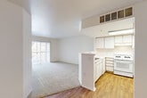 Located at 1025 Wakerobin Ln in Fort Collins, Colorado, this two-bedroom, one-bathroom single-story home offers a practical and well-organized layout. The open-concept living and kitchen area serves as the heart of the space, with the kitchen positioned behind a half-wall peninsula that creates a natural divide while maintaining an open feel. The kitchen is equipped with white cabinetry offering generous storage, a gas range, refrigerator, dishwasher, double sink, and a skylight that fills the space with natural light. Wood-style flooring runs through the kitchen and entry areas, transitioning to plush carpet in the living room and bedrooms. The spacious living room features a sliding glass door leading to a private patio, allowing natural light to flow freely throughout. The primary bedroom includes its own sliding glass door access to the outdoors, while the second bedroom features a window with exterior views. Both bedrooms are carpeted and well-proportioned. The full bathroom includes a vanity with under-sink storage, a wall mirror, and wood-style flooring. A dedicated utility room, hallway, and two closets add functional storage throughout. The clean, neutral palette and consistent finishes create a bright, cohesive ambiance throughout the home.