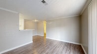 This single-floor, 2-bedroom, 2-bathroom home offers a thoughtfully arranged layout that maximizes functionality and comfort. The open-concept main living area seamlessly integrates the living room, dining room, and kitchen into one cohesive space. The living room features light wood-look laminate flooring, crown molding, a textured ceiling, and a sliding glass door that invites natural light and outdoor access. The kitchen is equipped with white cabinetry, a black dishwasher, a white refrigerator, and a raised breakfast bar countertop with speckled stone-look surfaces, providing both prep space and a casual dining option. A pantry offers additional storage for the kitchen. Both bedrooms are carpeted and include ceiling fans for added comfort. The primary bedroom features access to a walk-in closet with built-in shelving and a dedicated en-suite bathroom. A second full bathroom, complete with a tub-shower combination and white tile surround, a speckled vanity countertop, and wood-look flooring, serves the second bedroom and guests. Three closets throughout the home provide ample storage. The neutral color palette and consistent finishes throughout contribute to a clean, move-in-ready ambiance.