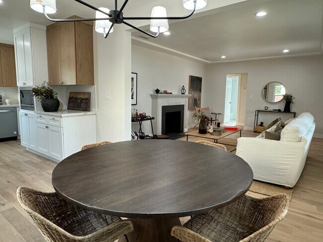 Comedor/cocina con electrodomésticos de acero inoxidable completamente nuevos a la izquierda y sala de estar a la derecha. - 5950 Simpson Ave